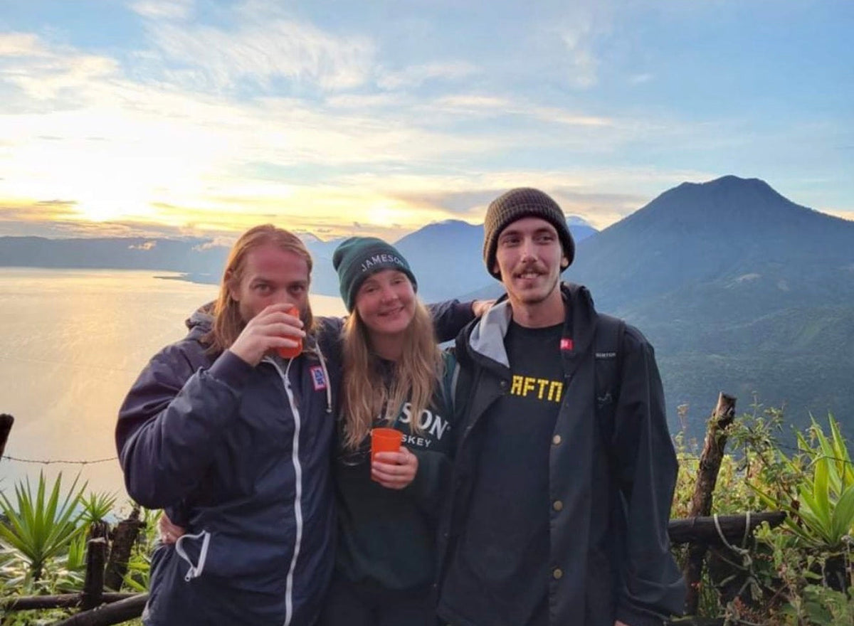 Guatemala: Mike Boisvert and two friends at sunset over Lake Atitlán, a volcano on the horizon. Photo by Mike Boisvert / The Skate Nomad