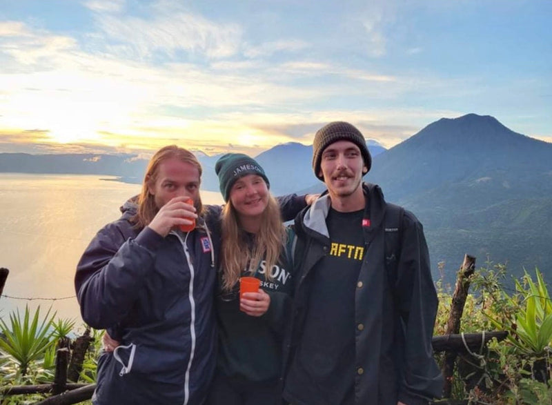 Guatemala: Mike Boisvert and two friends at sunset over Lake Atitlán, a volcano on the horizon. Photo by Mike Boisvert / The Skate Nomad