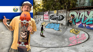 Skateboarding in El Salvador: Mike Boisvert holds up his board in front of a graffiti-covered bowl, the Salvadoran flag behind him. Photo by Mike Boisvert / The Skate Nomad