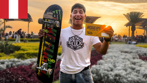 Skateboarding in Peru: Deyvid Anderson holds up his JACKALOPE Golden Ticket in Lima, Peruvian flag behind him. Photo by Mike Boisvert / The Skate Nomad
