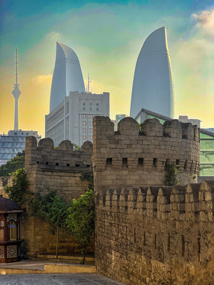 Baku, Azerbaijan: the stone walls of the old town glow at golden hour in front of the Flame Towers. Photo by Mike Boisvert / The Skate Nomad