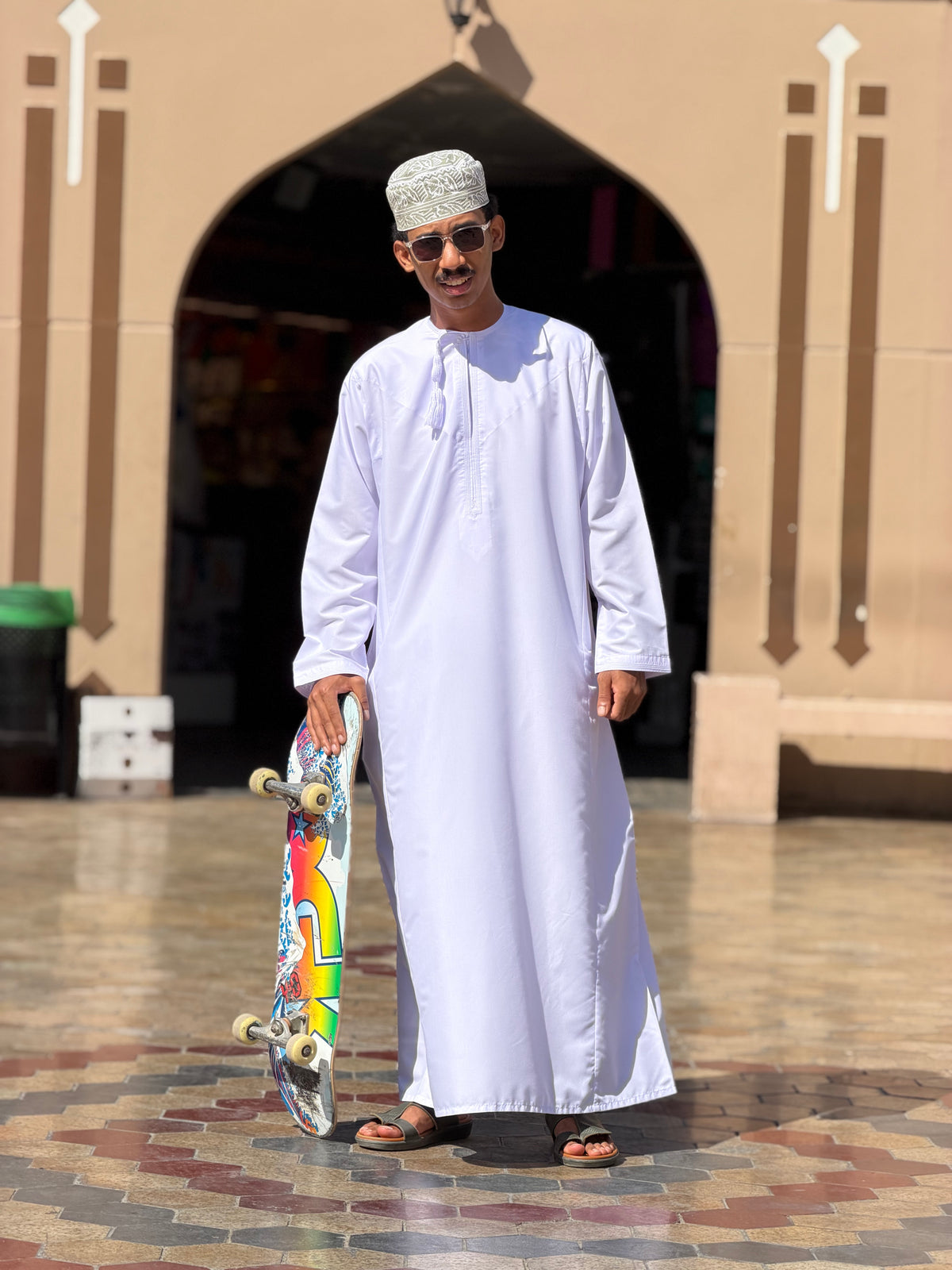 Muscat, Oman: a local skater in a dishdasha and kuma with his board. Photo by Mike Boisvert / The Skate Nomad