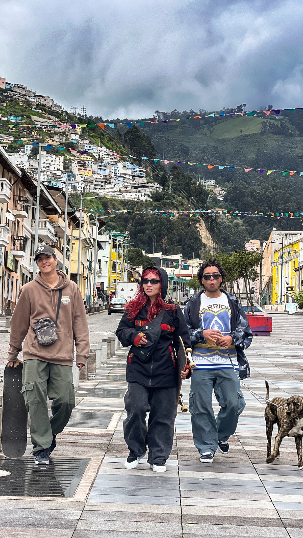 Quito, Ecuador: local skaters walk down a pedestrian street under strings of flags. Photo by Mike Boisvert / The Skate Nomad