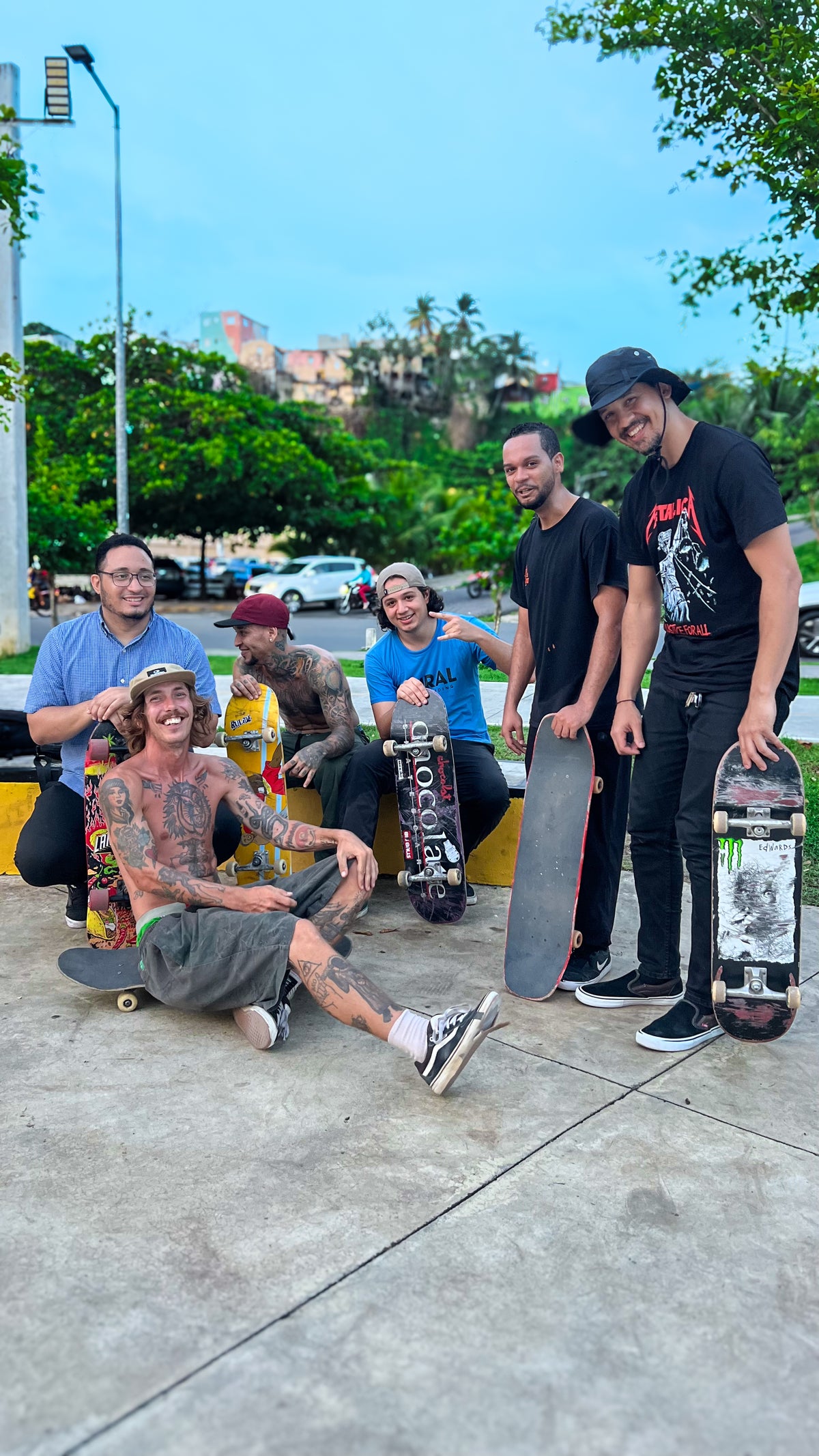 Skateboarding in the Dominican Republic: a crew of skaters with their boards on a plaza ledge under palm trees. Photo by Mike Boisvert / The Skate Nomad