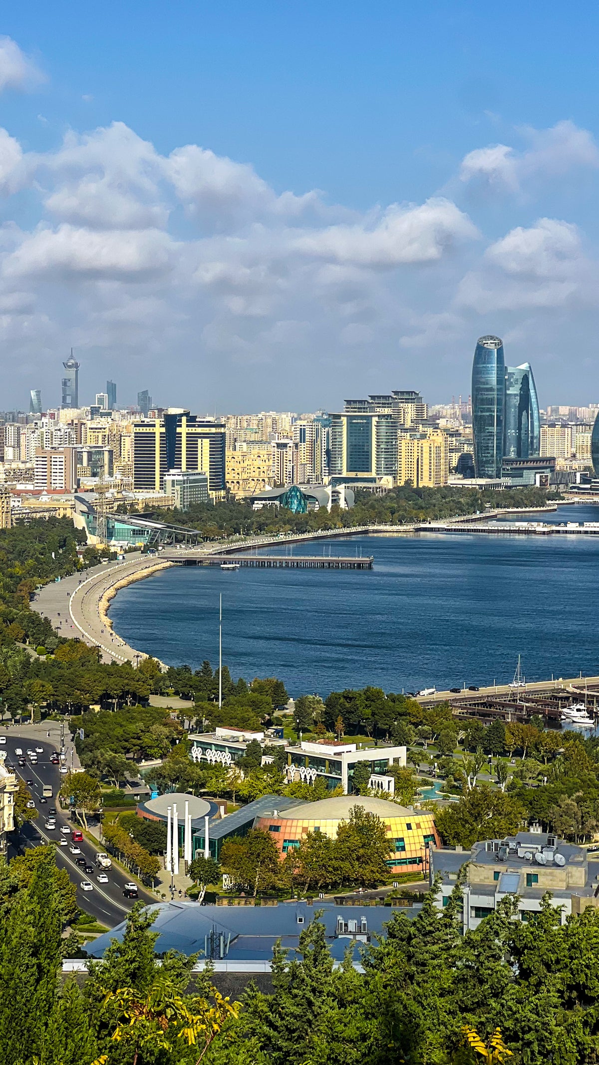 Baku, Azerbaijan: a view over a green hillside and the Caspian bay toward the skyline and the Flame Towers. Photo by Mike Boisvert / The Skate Nomad
