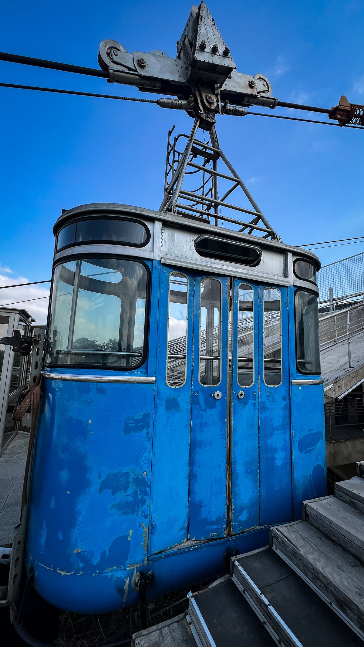 Georgia: an old blue cable car cabin against a bright blue sky. Photo by Mike Boisvert / The Skate Nomad