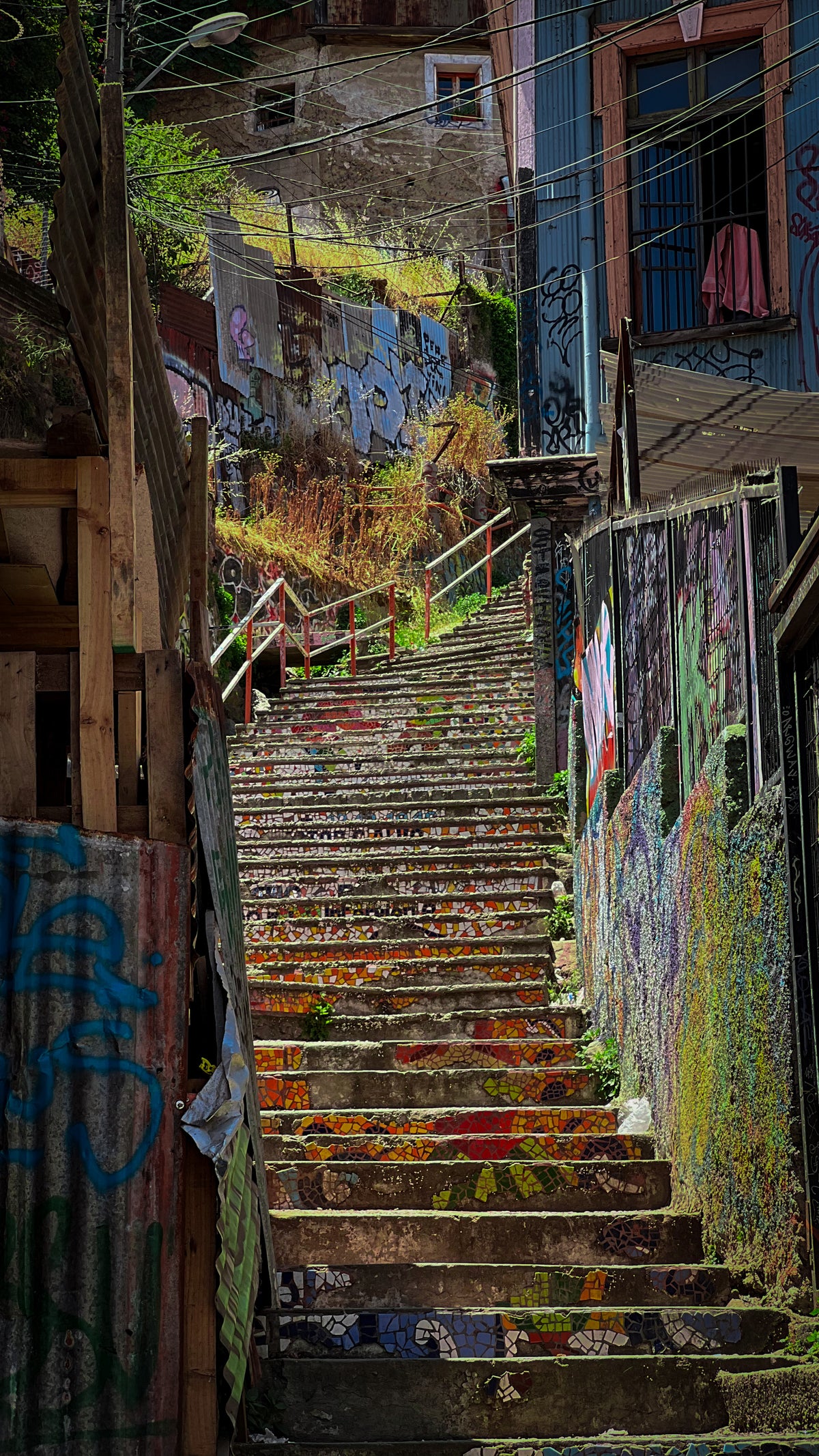 Valparaíso, Chile: a long painted staircase climbing through a graffiti-covered alley. Photo by Mike Boisvert / The Skate Nomad