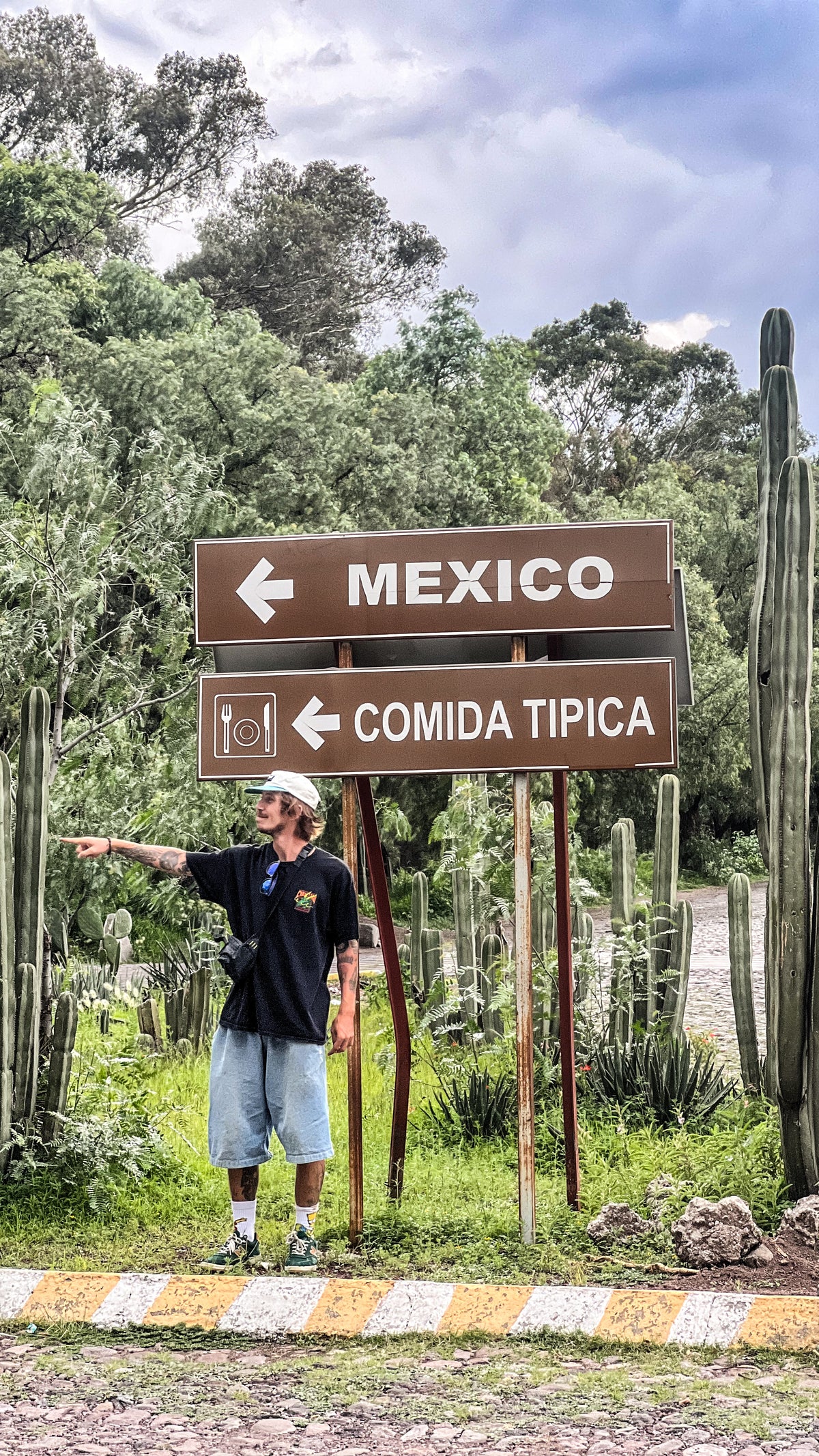 Mexico: Mike Boisvert points at a road sign reading Mexico, comida típica. Photo by Mike Boisvert / The Skate Nomad