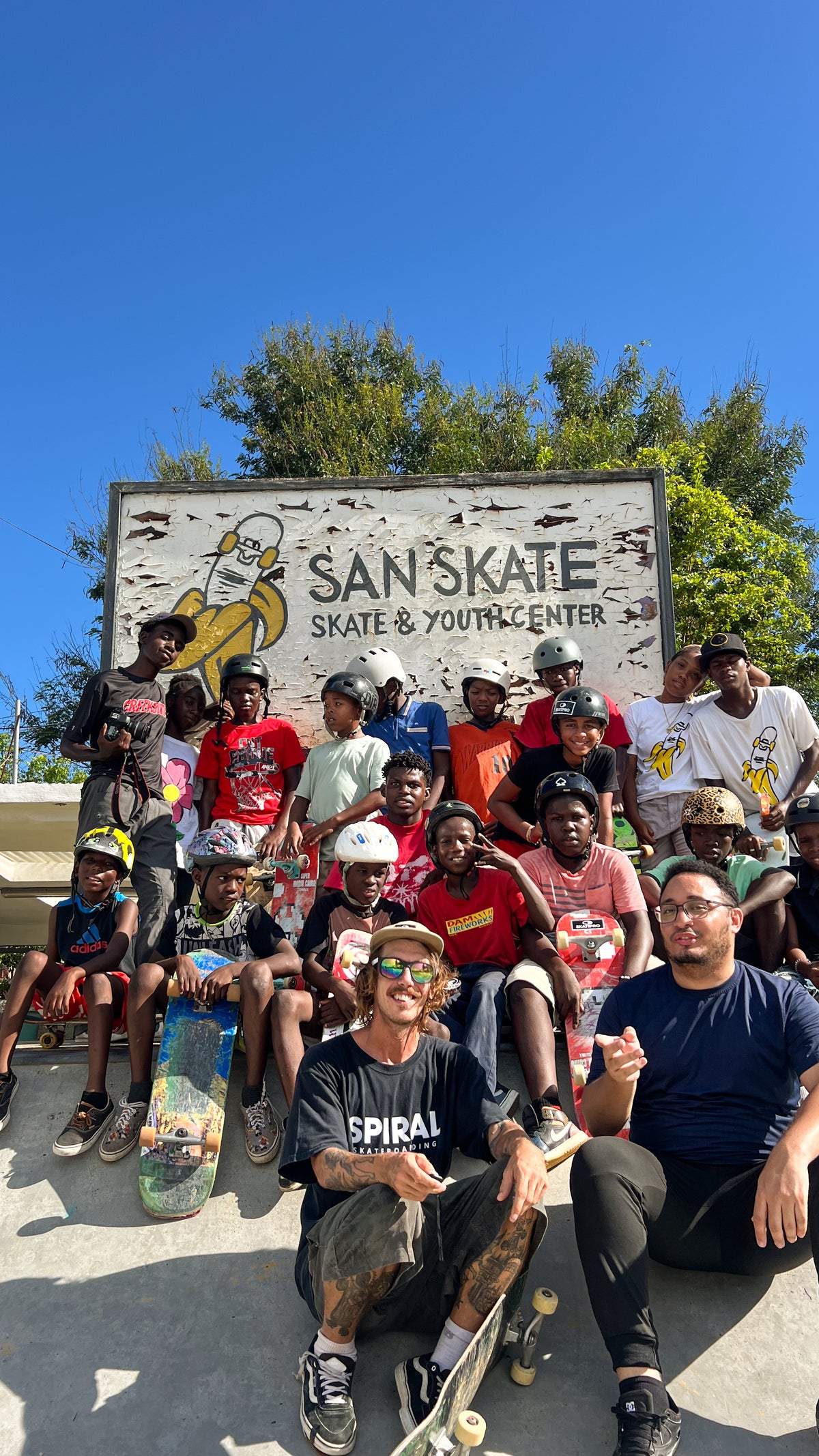 Skateboarding in Santo Domingo Este: young skaters gather with their boards in front of the San Skate sign. Photo by Mike Boisvert / The Skate Nomad