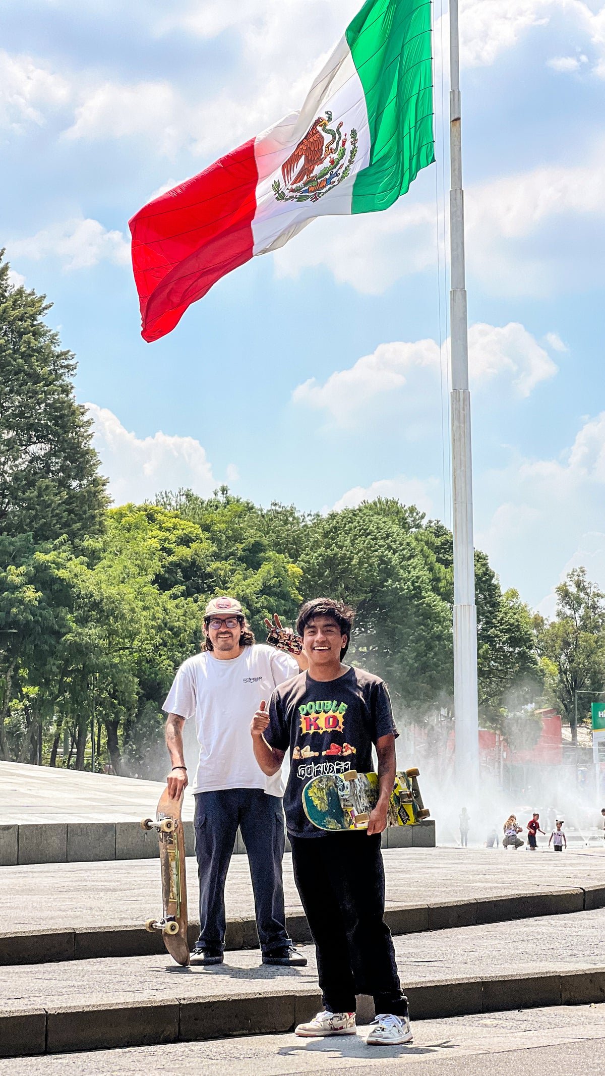 Skateboarding in Mexico City: Mike Boisvert and a local skater under a giant Mexican flag. Photo by Mike Boisvert / The Skate Nomad