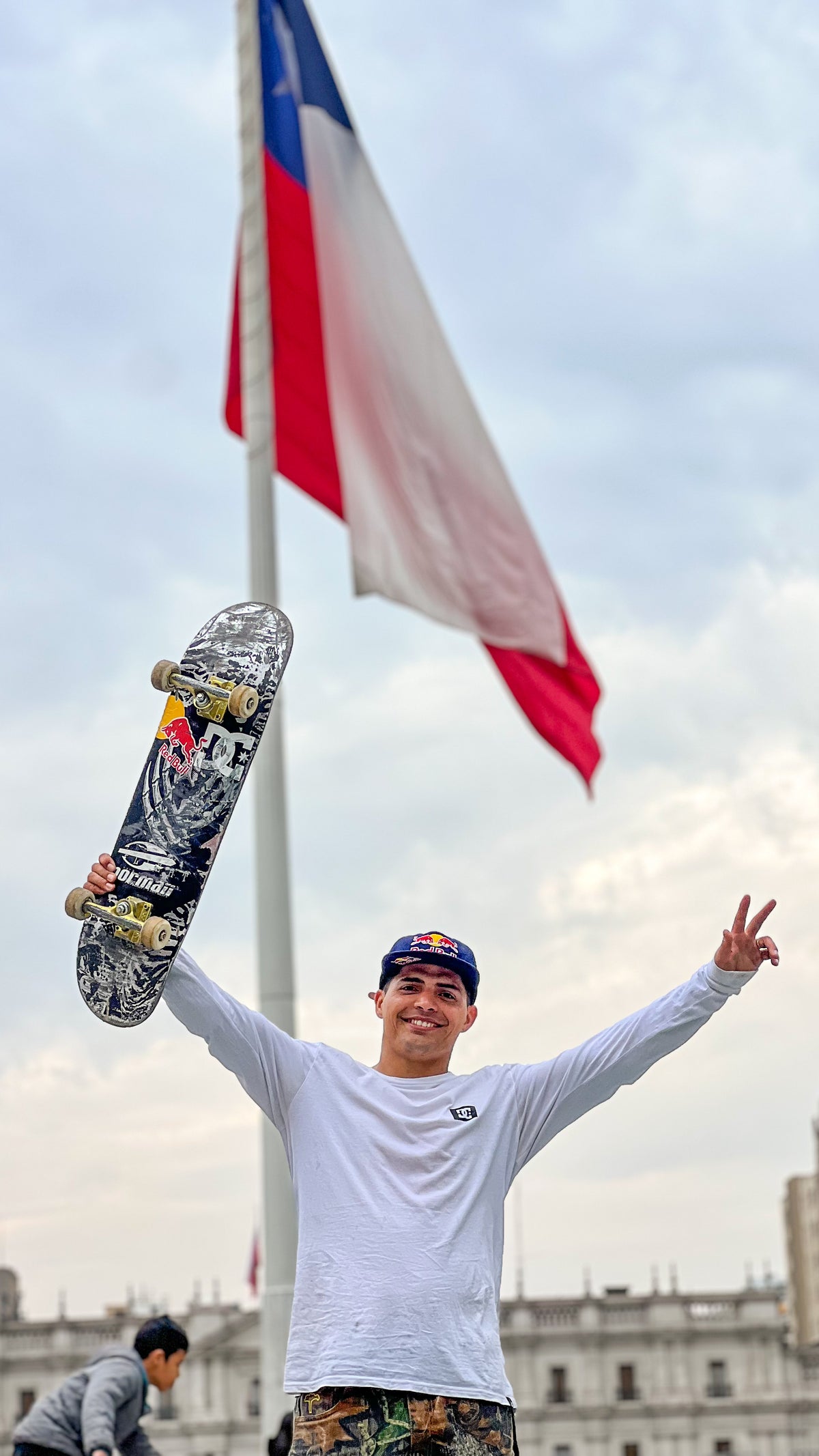 Skateboarding in Santiago, Chile: Marcelo Jiménez holds up his board under the Chilean flag. Photo by Mike Boisvert / The Skate Nomad