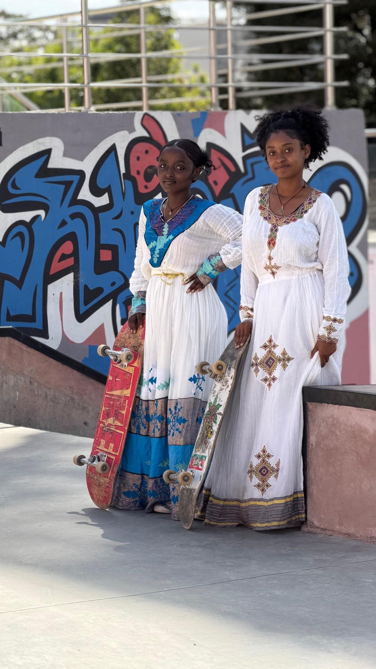 Skateboarding in Addis Ababa, Ethiopia — two skaters in habesha dresses at Addis Skatepark — photo by Mike Boisvert / The Skate Nomad